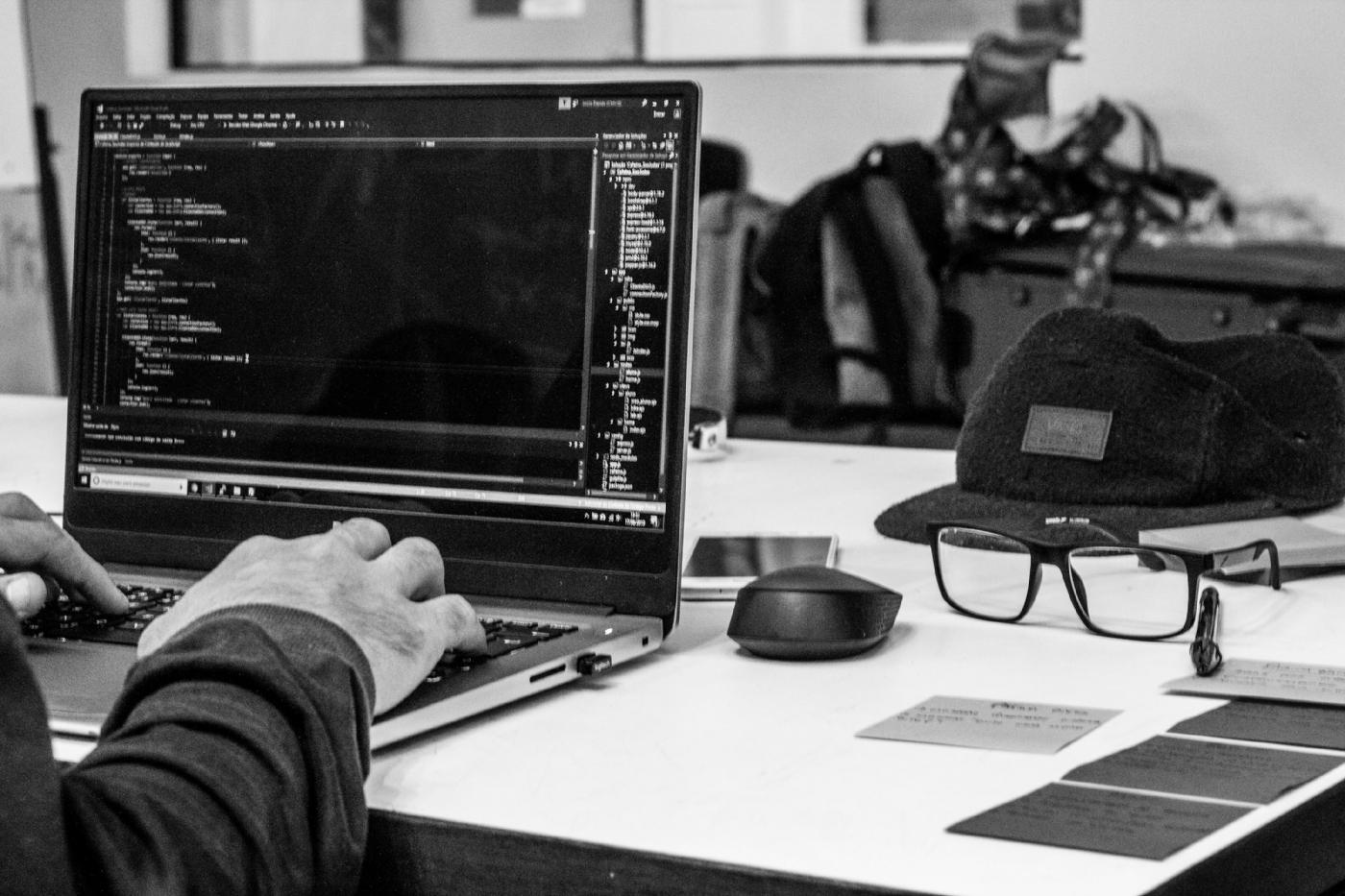 This image depicts a software developer coding on a laptop.